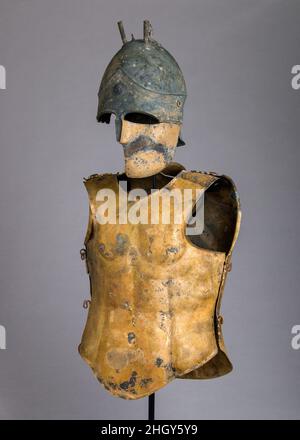 Helm des italo-chalcidischen Typs, anatomischer Cuirass und linker Greve Ende des 5th.–4th. Jahrhunderts v. Chr. Etrusker, wahrscheinlich Vulci Dieses Panoply besteht aus einem passenden Ensemble von Helm, Cuirass und Greve (Schienengüterschutz), Es handelt sich um seltene etruskische Werke, die die feinsten Eigenschaften der Form und der Dekoration veranschaulichen, die die größten Rüstungen charakterisieren, die in Etrurien während der klassischen Periode hergestellt wurden. Neben der Originalität des Designs und der außergewöhnlichen Verarbeitung nimmt dieses Ensemble einen wichtigen Platz in der historischen Entwicklung der etruskischen Rüstung ein. Es enthält eine der feinsten etruskischen Kürassen Stockfoto