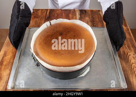 Hausgemachter baskischer, cremiger Käsekuchen, Käsekuchen im New Yorker Stil in einer runden Backform, dunkler Hintergrund, selektiver Fokus, Kopierraum. Modisches Dessert Stockfoto
