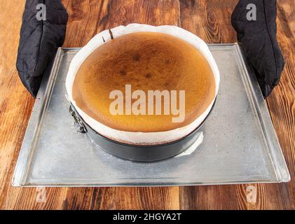 Hausgemachter baskischer, cremiger Käsekuchen, Käsekuchen im New Yorker Stil in einer runden Backform, dunkler Hintergrund, selektiver Fokus, Kopierraum. Modisches Dessert Stockfoto