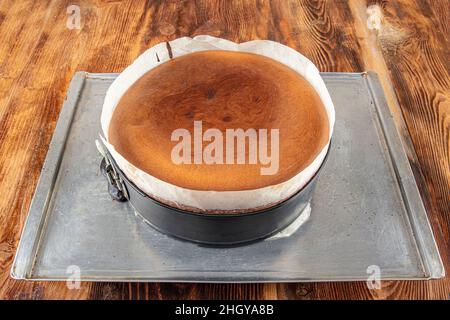 Hausgemachter baskischer, cremiger Käsekuchen, Käsekuchen im New Yorker Stil in einer runden Backform, dunkler Hintergrund, selektiver Fokus, Kopierraum. Modisches Dessert Stockfoto