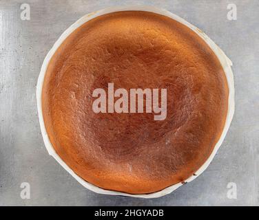 Hausgemachter baskischer, cremiger Käsekuchen, Käsekuchen im New Yorker Stil in einer runden Backform, dunkler Hintergrund, selektiver Fokus, Kopierraum. Modisches Dessert Stockfoto