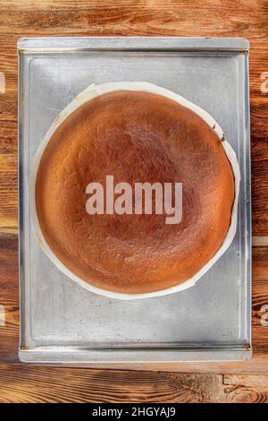 Hausgemachter baskischer, cremiger Käsekuchen, Käsekuchen im New Yorker Stil in einer runden Backform, dunkler Hintergrund, selektiver Fokus, Kopierraum. Modisches Dessert Stockfoto