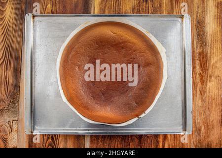 Hausgemachter baskischer, cremiger Käsekuchen, Käsekuchen im New Yorker Stil in einer runden Backform, dunkler Hintergrund, selektiver Fokus, Kopierraum. Modisches Dessert Stockfoto