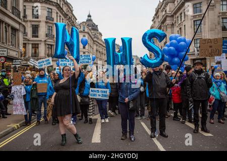 London, Großbritannien. 22nd Januar 2022. NHS-Mitarbeiter posieren für die Kamera, während sie während der Demonstration durch das Zentrum von London marschieren. Während einer weltweiten Kundgebung für die Freiheit marschierten die Demonstranten durch das Zentrum Londons und protestierten gegen die staatlichen Beschränkungen im Zusammenhang mit Covid 19, einschließlich obligatorischer Impfungen, insbesondere mit NHS-Mitarbeitern, die möglicherweise mit dem Verlust ihres Arbeitsplatzes konfrontiert sind, wenn sie sich weigern, sich impfen zu lassen. Kredit: SOPA Images Limited/Alamy Live Nachrichten Stockfoto