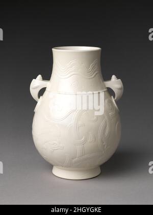 Vase in Form eines archaischen Bronzegefäßes 18th. Jahrhundert China die Form, die zwei stilisierten Elefantenköpfe, die die Ringe an den Seiten stützen, und die in die Oberfläche geschnitzte Dekoration verweisen auf die Formen und Designs, die in einigen der frühesten Bronzegefäße Chinas gefunden wurden, die während der Shang hergestellt wurden (ca. 1600–1050 v. Chr.) und Zhou (ca. 1050–256 v. Chr.) Dynastien. Diese frühen Gefäße, die in Hof- und Ahnenritualen verwendet wurden, wurden jahrhundertelang in Porzellan und anderen Medien neu geschaffen. Vase in Form eines archaischen Bronzegefäßes. China. 18th Jahrhundert. Weiches Porzellan (Jingdezhen Ware). Qing-Dynastie (1644– Stockfoto