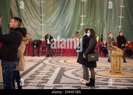 Bild eines weißen kaukasischen Mädchens, das in der orthodoxen Kirche des Heiligen Sava-Tempels eine Gesichtsmast für den Weihnachtsabend trägt, während es eine Schutzkleidung trägt Stockfoto