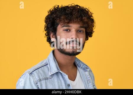 Junger indischer Kerl isoliert auf gelbem Hintergrund, Kopfschuss Nahaufnahme Porträt. Stockfoto