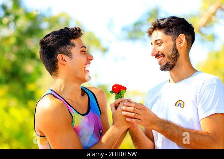 Glückliches schwules Paar, das Zeit zusammen an sonnigen Tagen im grünen Park verbringt Stockfoto