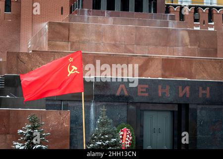 Die rote Flagge der Sowjetunion mit Hammer und Sichel auf dem Hintergrund des Lenin-Mausoleums. Kommunismus in Russland ist ein Konzept Stockfoto