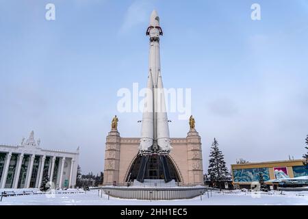 Die weltweit erste bemannte Vostok-dreistufige Weltraumrakete auf einer Ausstellung in Moskau. Vor einem Hintergrund von blauem Himmel und Schneeflocken. Übersetzung: Stockfoto