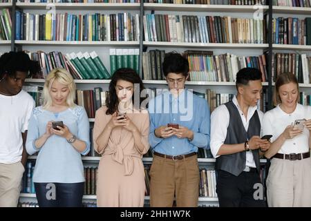 Eine multiethnische Gruppe von Neuling-Studenten, die mit dem Handy beschäftigt waren Stockfoto