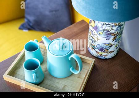 Teekannen und zwei blaue Tassen auf dem Tisch, Draufsicht. Stockfoto