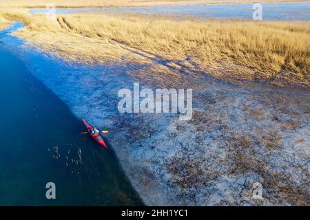 Kajakfahrer im roten Kajak auf dem halbgefrorenen intermittierenden See Cerknica, Slowenien Stockfoto