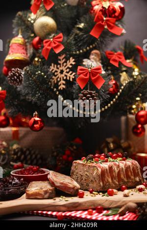 Traditionelle französische Terrine mit Speck und geschmücktem Weihnachtsbaum Stockfoto