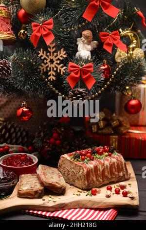 Traditionelle französische Terrine mit Speck und geschmücktem Weihnachtsbaum Stockfoto