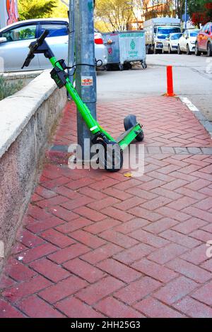 Der ausgeliehene E-Scooter „Marti“ parkte und kettete auf dem Bürgersteig an der Straße in Ankara, Türkei Stockfoto