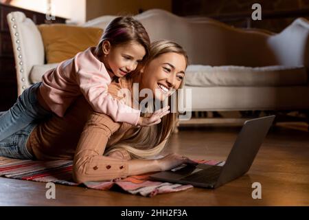 Lächelnde Frau und Mädchen mit dem Laptop winkende Hand Stockfoto