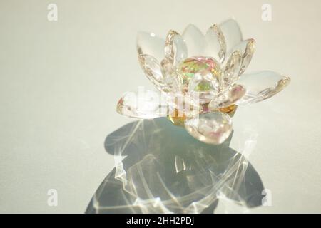 Wunderschöne Lotusblume aus Kristall auf einem grünen sonnigen Tisch. Stockfoto