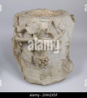 Marmor-Aschenurne in Form eines Baumstumpens mit Blättern und Trauben ca. 1st Jahrhundert A.D. Roman geschnitzt, um einen Baumstumpf mit einem abgeschnittenen Zweig auf der einen Seite und einer grünen Weinrebe zu imitieren, die auf der anderen klettert, bezieht sich diese Aschenurne auf den weingott Dionysus und seinen Sieg über den Tod. Römische Urnen des frühen Imperium imitieren häufig andere Formen und Materialien. Das hohe Relief des abgetrennten Astes, der Blätter und der Früchte erzeugt ein Wechselspiel von Licht und Schatten vor dem strukturierten Hintergrund der Rinde. Marmorurne in Form eines Baumstumpens mit Blättern und Trauben. Roman. Ca. 1st Jahrhundert n. Chr.. Ma Stockfoto