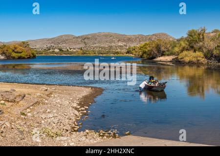 Mann waten, Schnellboot zur Bootsrampe auf Arivaca Lake, Atascosa Mountains, Coronado National Forest, Arizona, USA Stockfoto