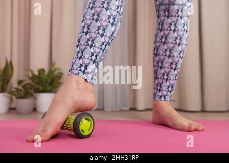 Nahaufnahme der Füße eines Mädchens, das zu Hause eine Myofaszialmassage macht Stockfoto