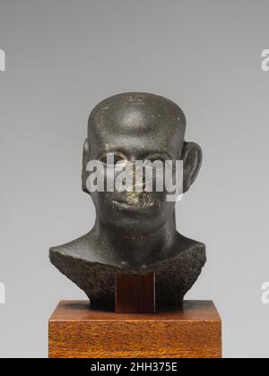 Kopf eines Mannes mit einem rasierte Kopf ca. 1802–1650 v. Chr. Reich der Mitte dieser fesselnde, kahlköpfige Mann hat einen großen Schädel mit markanten Details und einer allgemeinen Winkligkeit. Seine ungewöhnlichen Merkmale, insbesondere die U-förmige Vertiefung oben am Kopf, können darauf hindeuten, dass es das Produkt einer einzigartigen Skulpturenwerkstatt ist, die Statuen mit unverwechselbaren Stilelementen hervorbrachte. Kopf eines Mannes mit einem rasierte Kopf. Ca. 1802–1650 V. CHR. Metagraywacke. Reich Der Mitte. Aus Ägypten. Dynastie 13 Stockfoto