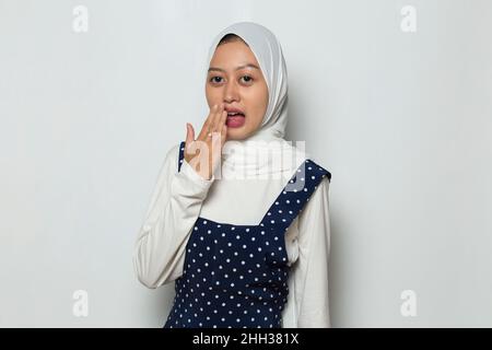 Junge asiatische muslimische Frau schockierte, den Mund aus Versehen mit Händen zu bedecken. Geheimes Konzept. Stockfoto