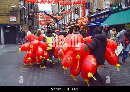London, Großbritannien 22nd. Januar 2022. Arbeiter tragen neue Laternen, die vor dem chinesischen Neujahr in Chinatown installiert werden sollen. Stockfoto