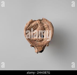 Terrakotta-Öllampe 1st Jahrhundert v. Chr.–1st Jahrhundert n. Chr. Römische Form gemacht. Großer Diskus: In hohem Relief, ein Adler mit der rechten Seite, mit offenen Flügeln und Kopf nach links gedreht, ergaß einen Hasen, der ebenfalls nach rechts lief; ein einziges Einfüllloch zwischen dem linken Flügel und dem Bein des Adlers; schmal angeschnittenes Schulterband, verziert mit eng anliegenden Ei-und-Dartpfeilen. Spiraldüsen an den Seiten der Düse. Basisring bestehend aus drei erhöhten konzentrischen Kreisen, und leicht unebene, einfache Basis; zwei erhöhte Bänder erstrecken sich nach unten Seite von den Enden der Spiralen zu Basisring.gebrochen mit viel Düse und Rückseite des Diskus und Körper fehlt.. Terrakotta-Öllampe. Roman Stockfoto