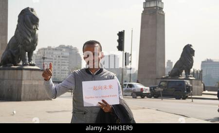 Peking, Ägypten. 18th Januar 2022. Nasar, ein Anbieter auf dem Khalili-Markt, posiert mit einem Papierdruck „Together for a Shared Future“, dem offiziellen Motto für Peking 2022, am 18. Januar 2022 in Kairo, Ägypten. Weniger als zwei Wochen vor dem Beginn der Olympischen Winterspiele 2022 in Peking bringen Menschen auf der ganzen Welt ihre Freude über die sportliche Extravaganz zum Ausdruck. Quelle: Wang Dongzhen/Xinhua/Alamy Live News Stockfoto