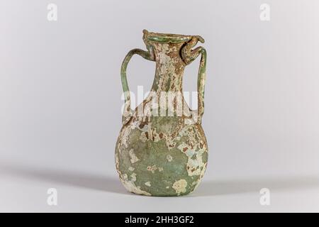 Glasflasche mit zwei Griff ca. Römisch-lichtdurchlässig, hellblau-grün, 4th. Jahrhundert n. Chr.; Griffe in gleicher Farbe; Rand ausgeklappt, rund und innen und zur Seite des auffaellenden Mundes abgeflacht; zylindrischer Hals in Missform; lentoider Körper mit Knollenseiten und leichten Werkzeugvertiefungen auf beiden Gesichtern; tiefer tritt im Boden mit kreisförmiger Pontil-Markierung; Zwei Stabgriffe, die als Pads auf die Seiten des Oberkörpers aufgetragen wurden, aufgezogen (einer gerade, der andere in einer Kurve), gedreht und auf die Oberseite des Halses, die Unterseite des Mundes und den Rand des Randes gezogen, mit abgerundeten hervorstehenden Enden.intakt; viele Nadelstichtblasen; stumpfend, pitting, cremige Stirn Stockfoto