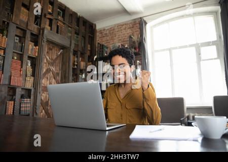 Aufgeregte afrikanische Geschäftsfrau, die sich über gute Nachrichten freut Stockfoto