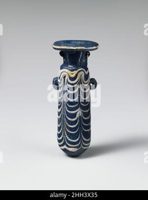 Glas-Alabastron (Parfümflasche) Ende 4th–Anfang 3rd Jahrhundert v. Chr. Griechisch, östliches Mittelmeer Halbopakes Kobaltblau, mit Griffen in gleicher Farbe; Trails in opak-weiß.breite horizontale Randscheibe, als Spiralspule um den Hals herum gemacht; kurzer zylindrischer Hals; schmale schräge Schulter; gerader zylindrischer Körper; konvexer Boden; Am Oberkörper zwei vertikale Ringgriffe, durchbohrt, über dem Trailmuster angebracht.Eine Spur, die am Rand der Randscheibe befestigt ist; eine weitere Spur, die von der Schulter bis zum Rand der Unterseite aufgetragen wird, zu einem Festoon-Muster mit sechs Aufwärtsschlägen geschwenkt, wobei oben am Körper Schlaufen gebildet werden.intakt, Stockfoto