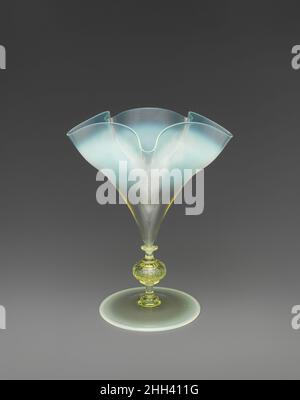 Vase mit geklopftem Stiel ca. 1880 Harry Powell British zugeschrieben Diese Vase ist ein sehr schönes Beispiel für die Serie von Vasen, die von Harry Powell (Enkel des Weinhändlers James Powell, der 1834 die Whitefriars Glassworks gekauft hatte) entworfen wurde. Die Entwürfe von Harry Powell aus den Jahren 1880s und 90s schufen eine ganze Reihe von dekorativen Gefäßen, die sich durch fein gewellte Schalen und dezent getöntes Glas auszeichneten. Die Silhouette der Vase und die Feinheit des Glases, die durch die Rüschen der Schale betont wird, sind vom venezianischen cristallo inspiriert. Das flüssige Design der zart regelmäßigen Wellen der Schüssel i Stockfoto