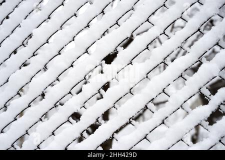 Zaunnetz angesammelt mit Schnee, Struktureffekt, Hintergrund Stockfoto