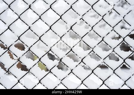 Zaunnetz angesammelt mit Schnee, Struktureffekt, Hintergrund Stockfoto