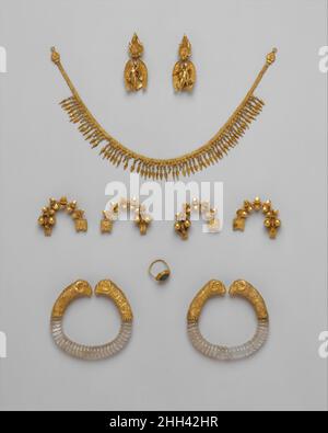 Ganymed Schmuck ca. 330–300 v.Chr. Griechisch die Stücke dieser Gruppe sollen vor 1913 in Mazedonien, nahe Thessaloniki, zusammen gefunden worden sein. Die Assemblage bildet einen beeindruckenden Parure (Matched Set) - Ohrringe, Halskette, Fibeln (Pins), Armbänder, Und einen Ring - aber es ist nicht sicher, dass sie zusammengehören, denn die Stücke zeigen keine klare Stilhomogenität.die Goldbandkette, datiert um 300 v. Chr., besteht aus drei doppelten Loop-in-Loop-Ketten mit doppelter Verkettung und einem Rand aus beechnut-Anhängern. Die Terminals haben die Form eines Efeus oder Traubenblattes und einen Rand aus Perlen Stockfoto