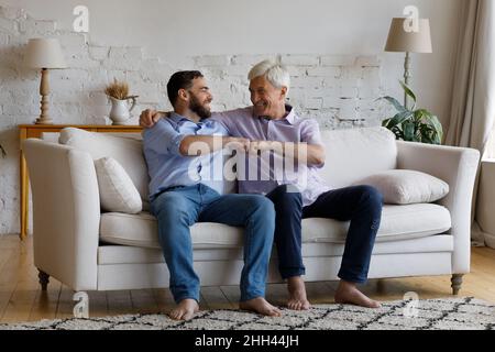 Glücklich reifen grauhaarigen Vater gratuliert erwachsenen Sohn zum Erfolg Stockfoto