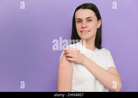 Lady bekommt geimpfte Immunität gegen Covid-19, empfohlene Impfung, Coronavirus-Programm, isoliert auf violettem Hintergrund mit leerem Raum. Weibliches Kätzchen Stockfoto