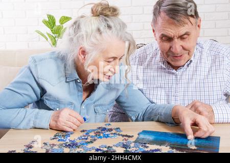 Ältere Paare lösen Puzzle zusammen zu Hause Stockfoto