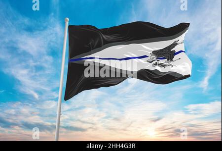 Blaue Flagge des amerikanischen Staates Samoa, USA bei bewölktem Himmel bei Sonnenuntergang, Panoramablick. Vereinigte Staaten von Amerika Polizeiflagge. Platz für w kopieren Stockfoto