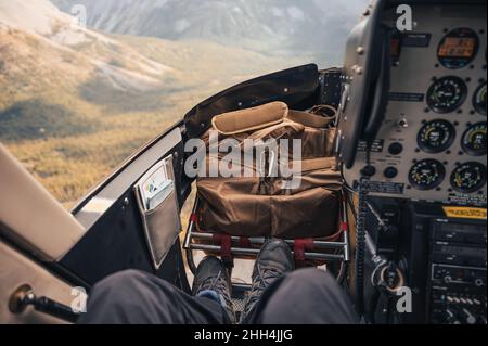 Im Cockpit fliegt ein Hubschrauber über die Rocky Mountains im Nationalpark Stockfoto