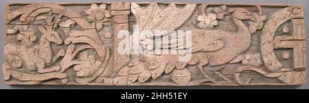 Relief Frieze 6th Century Coptic Ein Löwe und ein Leopard sprinten in die Mitte dieses hölzernen Sturzes, während andere Tiere friedlich sitzen. Paradiesische Pfauen bewachen eine gemmierte Kreuzung zwischen wabenden Vorhängen, drapiert und hinter zwei Säulen gehalten. Ein durchgehender, dekorativer Stiel aus Reben, Blumen und Trauben umkreist die Tiere in sechs Medaillons und kreiert ein Motiv, das als Rinceau bekannt ist. Die ursprünglichen hellen Blau-, Pink- und Grüntöne hätten die Dekoration des Sturzes belebt. Der Künstler verschmolz klassische Motive, die typischerweise Wohlstand mit christlichen Themen repräsentieren würden, möglicherweise illustriert Stockfoto