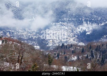 Winterlandschaft in der Bergregion Evritania, in Mittelgriechenland, Europa. Im Hintergrund ist Megalo Chorio, ein schönes traditionelles Dorf. Stockfoto