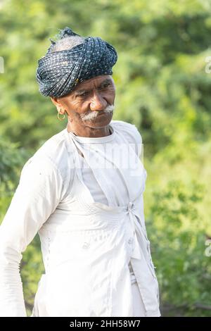 JAWAI, Rajasthan, Indien - September 2021: Porträt eines männlichen Hirten der ethnischen Gruppe der Rabari in einem nationalen Kopfschmuck und einem traditionellen weißen Kleid, Stockfoto