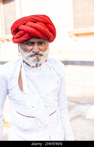 JAWAI, Rajasthan, Indien - September 2021: Porträt eines männlichen Hirten der ethnischen Gruppe der Rabari in einem nationalen Kopfschmuck und einem traditionellen weißen Kleid, Stockfoto
