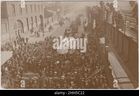 1911 Generalstreik des Liverpooler Verkehrs: Menschenmenge um Pferde und Karren. Einige Männer beobachten die Ereignisse von der Seite einer erhöhten Eisenbahnlinie aus. Foto von Carbonora Stockfoto