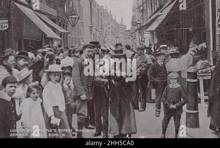 'London Workpeople's Street Markets, Berwick Street, Soho', ca. 1914: Menge Londoners auf der Straße, ein Schild für eine Saloon Bar ist im Hintergrund Stockfoto