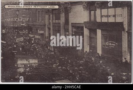 Middlesex Street, Petticoat Lane, Anfang des 20.. Jahrhunderts: Szene mit überfüllten Straßen, die einen Teil des Petticoat Lane Market zeigt. Im Hintergrund ist ein Showroom für Schuh- und Schuhfaktoren zu sehen Stockfoto