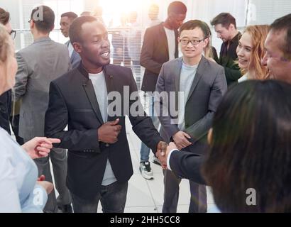Zwei interkulturelle busines Partner handshaking nach Unterzeichnung der Partnerschaft mit einigen Kollegen in der Nähe von Stockfoto